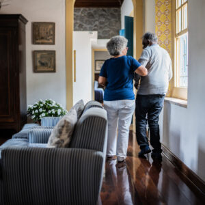 Wife helping husband walking at home
