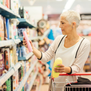 An older woman with short white hair shops in the healthcare aisle of a store.